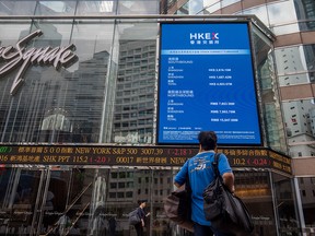 A pedestrian reads stock figures outside the Exchange Square complex, which houses the Hong Kong Stock Exchange, in Hong Kong on Sept. 16, 2019.