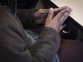 "Adam" gestures as he speaks with Cst. Abdi Hassan and social worker Komal Kardar, both not shown, about his involvement in the de-radicalized youth program in Calgary, Wednesday, Sept. 11, 2019.