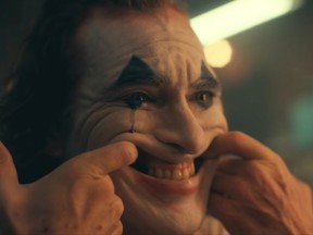 An image of Arthur Fleck forcing a smile in a trailer for the film, Joker