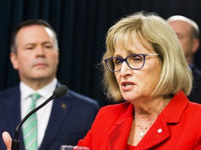 Premier Jason Kenney listens to Janice MacKinnon, a former Saskatchewan finance minister, and chair of a blue-ribbon panel announced to examine the Alberta government's financial situation.