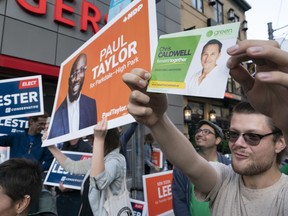 Supporters from various parties hold up campaign signs outside the studio of the first election debate in Toronto, on Thursday, Sept. 12, 2019.