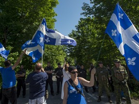 Protesters wave Quebec flags during a rally against illegal border crossings near Saint-Bernard-de-Lacolle, Que., on June 3, 2018.