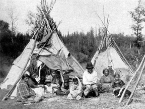 An Indigenous Canadian family gathers in front of a traditional shelter in 1880. A defamation lawsuit in Toronto hinges on whether the popular campfire song Land of the Silver Birch is “racist.” Critics of the song allege that it romanticizes and stereotypes Indigenous life.