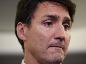 Liberal Leader Justin Trudeau reacts as he makes a statement in regards to photo coming to light of himself from 2001 wearing "brownface" during a scrum on his campaign plane in Halifax, N.S., on Wednesday, September 18, 2019.
