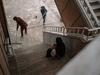 A woman holding a child sits on the stairs of a hospital in Derik, Syria, where women, who are held at a camp for alleged relatives of ISIL militants, are sent for medical care.