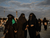 Veiled women walk together at al-Hol camp in northeastern Syria.