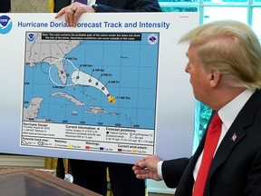 U.S. President Donald Trump references a map held by acting Homeland Security Secretary Kevin McAleenan while talking to reporters following a briefing from officials about Hurricane Dorian in the Oval Office at the White House September 04, 2019 in Washington, D.C.