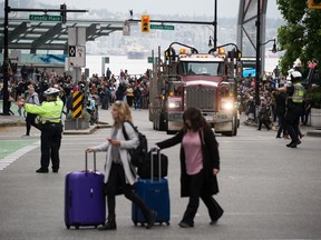 People gather to watch a convoy of logging trucks in downtown Vancouver, on Wednesday September 25, 2019. A convoy of approximately 200 logging trucks drove to Vancouver from Merritt as owners and drivers hoped to highlight the effects from dozens of mill closures and thousands of layoffs in British Columbia's forest industry.