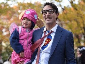 Prime Minister Justin Trudeau, dressed as DC Comics character Clark Kent, holds his son Hadrien, dressed as Paw Patrol character Skye, as they go trick-or-treating at Rideau Hall on Halloween in Ottawa on Tuesday, Oct. 31, 2017.