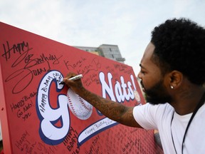 Montez Dove signs a board near Nationals Park, the Washington Nationals Stadium, in Washington, D.C. on October 25, 2019.