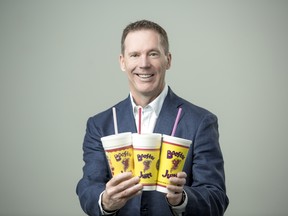 Booster Juice founder and CEO Dale Wishewan with three iconic cups used in store over the last 20 years in business.