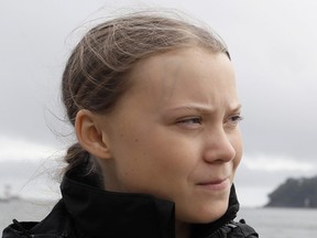 Swedish climate activist Greta Thunberg walks along the quayside to board an electric powered rib, before travelling to board the Malizia II IMOCA class sailing yacht off the coast of Plymouth, southwest England, on Aug. 14, 2019.