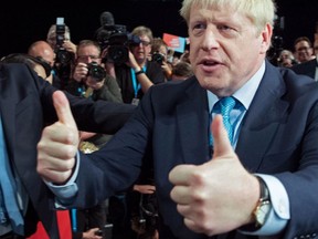 Britain's Prime Minister Boris Johnson (R) acknowledges the applause from Britain's Chancellor of the Exchequer Sajid Javid (not pictured) and members of his cabinet as he leaves after delivering his keynote speech to delegates on the final day of the annual Conservative Party conference at the Manchester Central convention complex, in Manchester, north-west England on October 2, 2019.