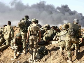 Turkish troops and Turkish-backed Syrian rebels gather outside the border town of Ras al-Ain on October 12, 2019, during their assault on Kurdish-held border towns in northeastern Syria.