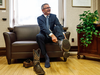 Alberta Finance Minister Travis Toews puts on a pair of cowboy boots during a pre-budget photo op in Edmonton on Oct. 23, 2019.