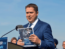 Conservatives Leader Andrew Scheer holds a copy of his party's campaign platforn in Delta, B.C., Oct. 11, 2019.