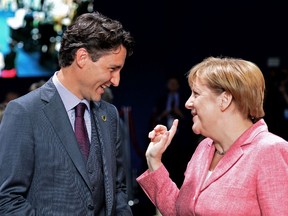 Canadian Prime Minister Justin Trudeau (L) talks to German Chancellor Angela Merkel during a NATO Summit session on Ukraine at the NATO Summit in Warsaw, Poland on July 9, 2016.