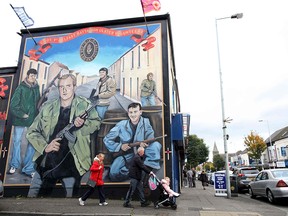 Pedestrians walk past a Loyalist Ulster Volunteer Force (UVF) mural on Shankill Road in Belfast, Northern Ireland, on Oct. 19, 2019.