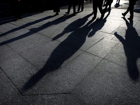 People cast their shadows on the sidewalks as they make their way home after work in downtown Toronto on Tuesday, Feb. 24, 2009. A new report says it would take Canada 164 years to close the economic gap between men and women if things keep going the way they are.