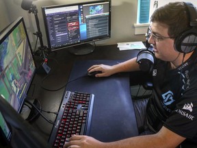 In this Sept. 11, 2018 file photo, Nick Overton, a professional video game player, plays "Fortnite" while engaging with his fans online from the game room at his home, in Grimes, Iowa. A Quebec law firm is seeking authorization to launch a class action lawsuit against the makers of the Fortnite video game, alleging it is highly addictive and can cause health problems.