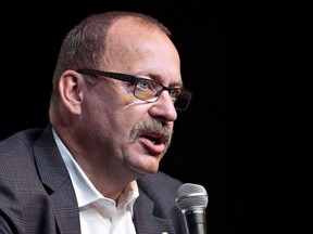 Ric McIver speaks in Edmonton on Aug. 21, 2014. Alberta Transportation Minister McIver says there will be a two-year probationary period for 6,800 bus and truck drivers who passed their exams before new training rules took effect.