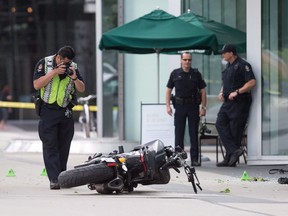 A police officer photographs a motorcycle after a female stunt driver working on the movie "Deadpool 2" died after a crash on set, in Vancouver, B.C., on Monday August 14, 2017.  British Columbia's workplace safety agency says multiple failures of a production company contributed to the death of a stunt performer on the set of "Deadpool 2."