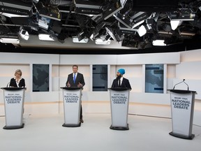 A empty podium stands where Liberal Leader Justin Trudeau turned down the invitation for the debate as Green Party Leader Elizabeth May, left, Conservative Leader Andrew Scheer, centre, and NDP Leader Jagmeet Singh take part during the Maclean's/Citytv National Leaders Debate in Toronto on Thursday, Sept. 12, 2019.