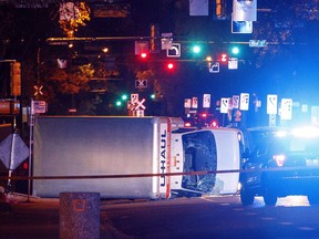 Police investigate the scene after a cube van ran into pedestrians and later flipped over while being pursued by police, in Edmonton on Saturday, September 30, 2017. A jury trial starts today for a man accused of trying to kill an Edmonton police officer and four pedestrians two years ago.