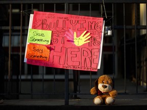 A sign and stuffed animal lay at the entrance to Sir Winston Churchill Secondary School ahead of a vigil for murdered 14-year-old Devan Selvey, at his high school, in Hamilton, Ont., Wednesday, Oct. 9, 2019. Hearing about the stabbing death of a 14-year-old boy outside a school in Hamilton has Darrel Crimeni grappling with questions of bullying and a lack of empathy that may also have played a role when his grandson's overdose was filmed and posted on social media.