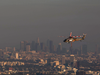 A rescue helicopter flies over Brentwoond while the Los Angeles skyline is seen behind smoke from the Getty Fire as seen from Brentwood, California, on Oct. 28, 2019.