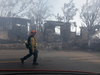 A firefighter walks past houses burned by the Getty Fire on Oct. 28, 2019 in Los Angeles, California.