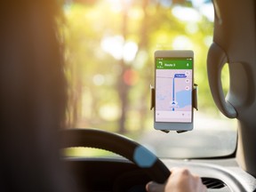 A woman checks Google Maps while driving her car.