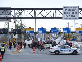 Members of Extinction Rebellion, protesting issues related to climate change, gather at the Angus L. Macdonald Bridge in Dartmouth, N.S. on Monday, Oct. 7, 2019.