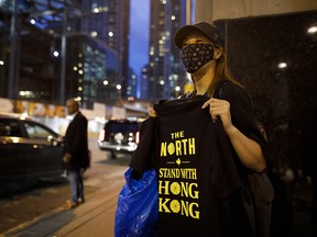 Pro-Hong Kong activists hand out T-shirts outside the Toronto Raptors' season opening game in Toronto on Oct. 22, 2019.