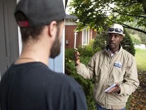 Abdul Abdi, Conservative candidate for Ottawa West-Nepean, speaks with a resident as he goes campaigning door to door in Ottawa on Saturday, Sept. 28, 2019.