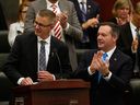 Alberta Finance Minister Travis Toews, left, is applauded by Premier Jason Kenney after Toews delivered his budget at the Alberta Legislature in Edmonton on Oct. 24, 2019.