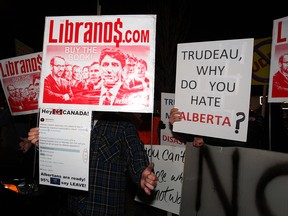 Conservative supporters hold anti-Liberal signs prior to Liberal Leader Justin Trudeau taking to the stage at an election rally in Calgary on Oct. 19, 2019.