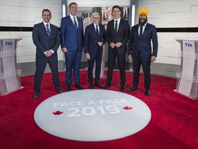 Leader of the Bloc Quebecois Yves-Francois Blanchet, left to right, Conservative Leader Andrew Scheer, TVA host Pierre Bruneau, Liberal Leader Justin Trudeau and NDP Leader Jagmeet Singh pose for a photo at the TVA french debate for the 2019 federal election, in Montreal, Wednesday, Oct. 2, 2019.
