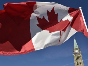 A Canadian flag is photographed with the Peace Tower in the background on Parliament Hill in Ottawa.