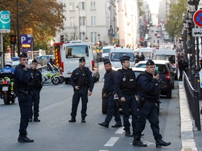 Police officers stand ready near Paris prefecture de police (police headquarters) on October 3, 2019 after four officers were killed in a knife attack.