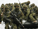 Reservists in full tactical gear exit an assault boat during a landing exercise at CFB Kingston in 2018. Part-time soldiering makes Canada's reservists among the best and smartest citizens, Christie Blatchford writes.