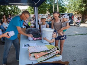 Vladimir Kozlov distributes MCC relief supplies to families in Ukraine displaced by conflict. The resources, including comforters, canned meat, relief kits and school kits, were distributed through MCC partner New Life Fund in Nikopol, Ukraine.