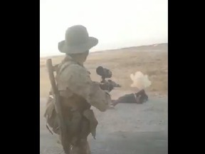 A Turkish soldier allegedly shoots at the body of a Kurdish captive in this screenshot.