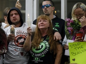 Shari-Ann Bracci-Selvey, centre, fights back tears at a vigil for her 14-year-old murdered son, Devan Selvey, at his high school, Sir Winston Churchill Secondary School, in Hamilton, Ont., Wednesday, Oct. 9, 2019.