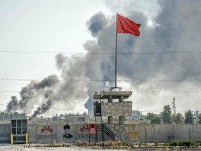 A picture taken in Akcakale at the Turkish border with Syria on October 10, 2019 shows smokes rising from the Syrian town of Tal Abyad after a mortar fired from Syria landed in the garden of a Turkish government building in Akcakale.