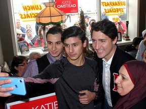 A Syrian family sponsored by the community take a selfie with Liberal Leader Justin Trudeau during a campaign stop in Tilbury, Ont., on Oct. 15, 2019. From left to right are Hamid Alhajjeh, 19, his brother Mulham Allajjeh, 18, and their mother Noura Alchreifi.