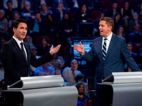 Conservative leader Andrew Scheer (R) and Canadian Prime Minister and Liberal leader Justin Trudeau gesture to each other as they both respond during the Federal Leaders Debate at the Canadian Museum of History in Gatineau, Quebec on October 7, 2019.