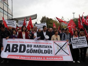 Supporters of the Homeland Party hold a banner that reads, "The USA is buried in this map!"  and Turkish national flags during a protest near the US Embassy in Ankara on October 8, 2019.