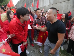 Pro-China counter-protesters, wearing red, shout down a man in a black shirt during an anti-extradition rally for Hong Kong in Vancouver on Saturday August 17, 2019.