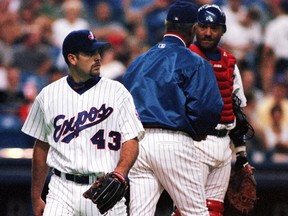 Starting Expos pitcher Dan Smith is pulled from the game as manager Felipe Alou speaks to catcher Robert Machado during acton against the Atlanta Braves in Montreal.